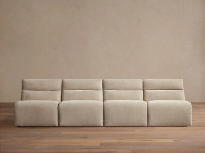 Light beige Rowland Tailored 4-piece armless modular sofa, seen straight-on against a beige wall with a wooden floor.