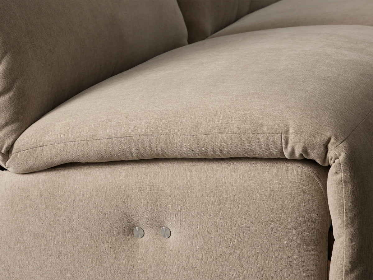 Close-up of Rowland Tailored Sofa's textured beige fabric with two brushed silver, circular metal buttons.