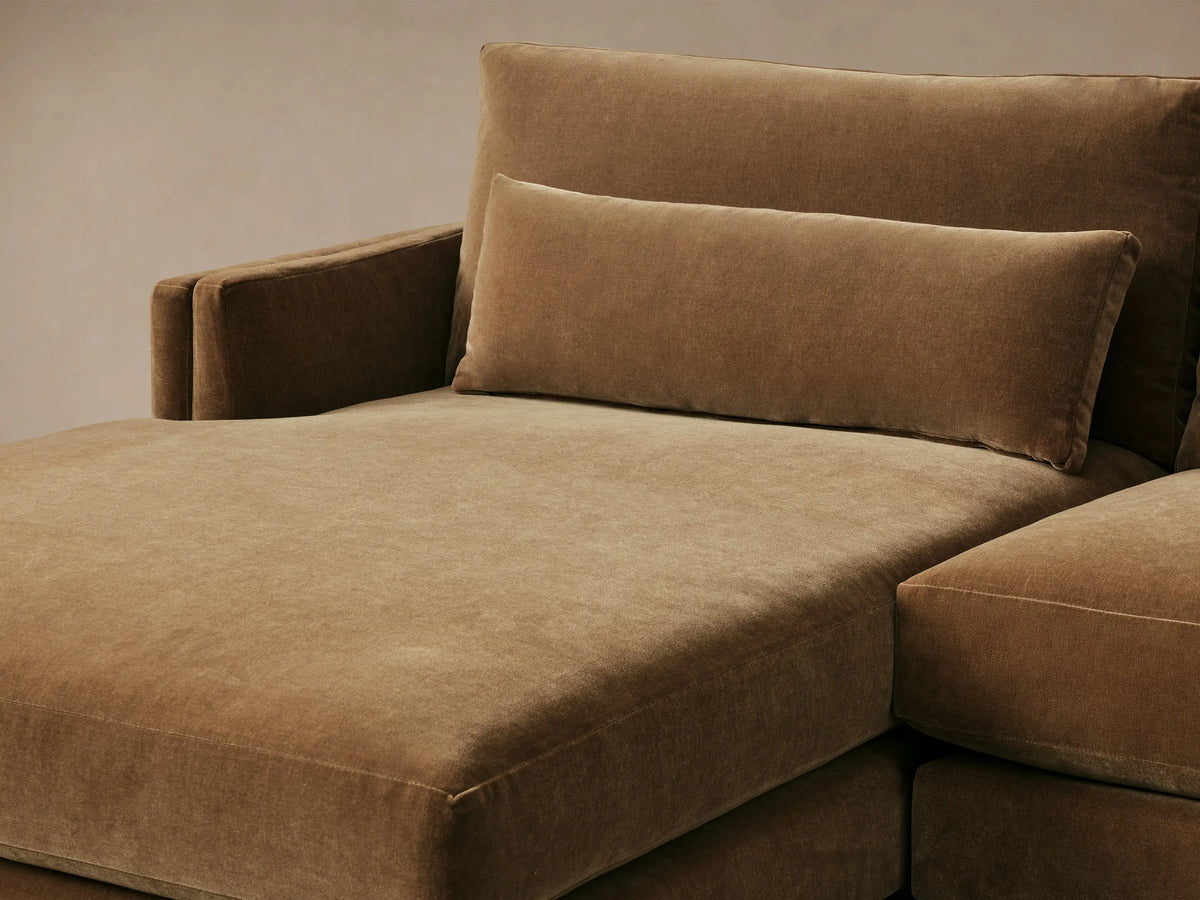 Front view of a golden-brown velvet Sumner Two-Piece Chaise Sectional with a left-facing chaise and three lumbar pillows.