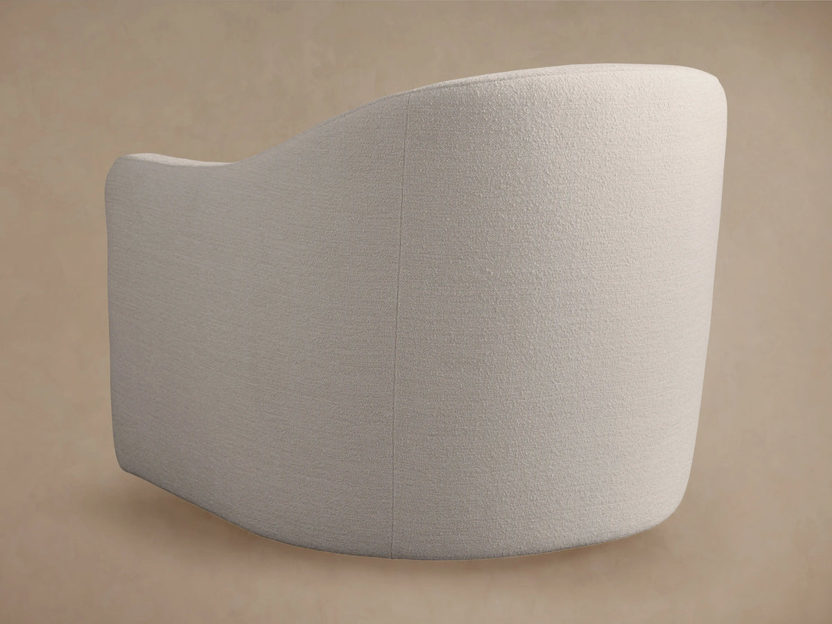 Off-white Bianca Swivel Chair in textured fabric, with rounded back & arms, separate seat & back cushions, on wood floor.