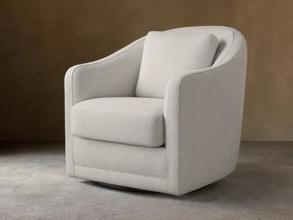 Off-white Bianca Swivel Chair in textured fabric, with rounded back & arms, separate seat & back cushions, on wood floor.