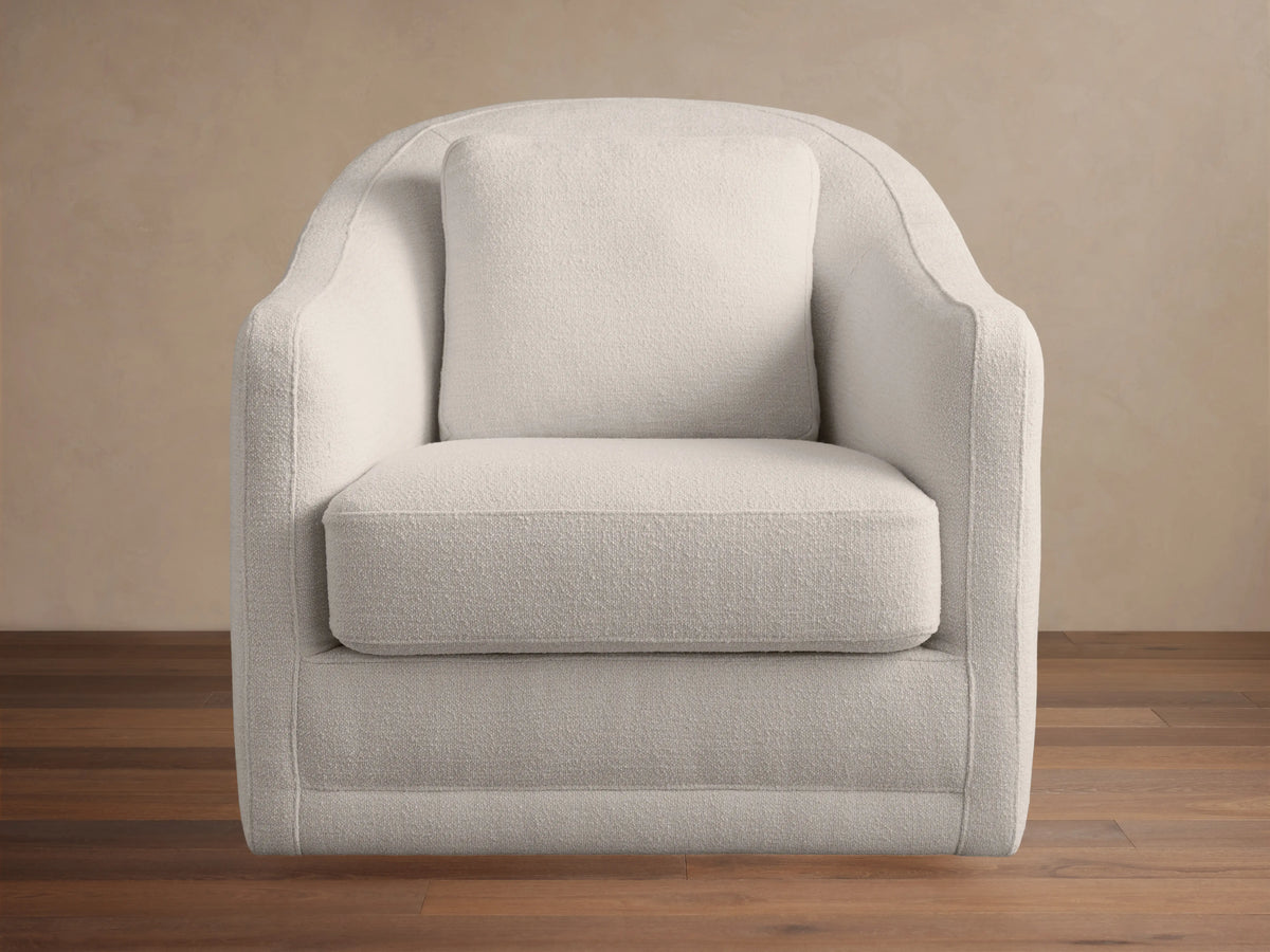 Bianca Swivel Chair, modern curved back, light cream textured performance fabric, angled side view on neutral background.