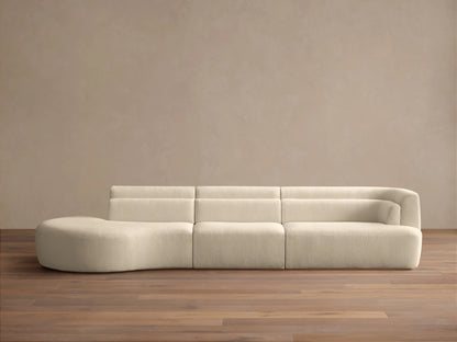 Lovina Three-Piece Bumper Sectional in cream textured fabric, with a rounded chaise left and armrest right, on a wooden floor.