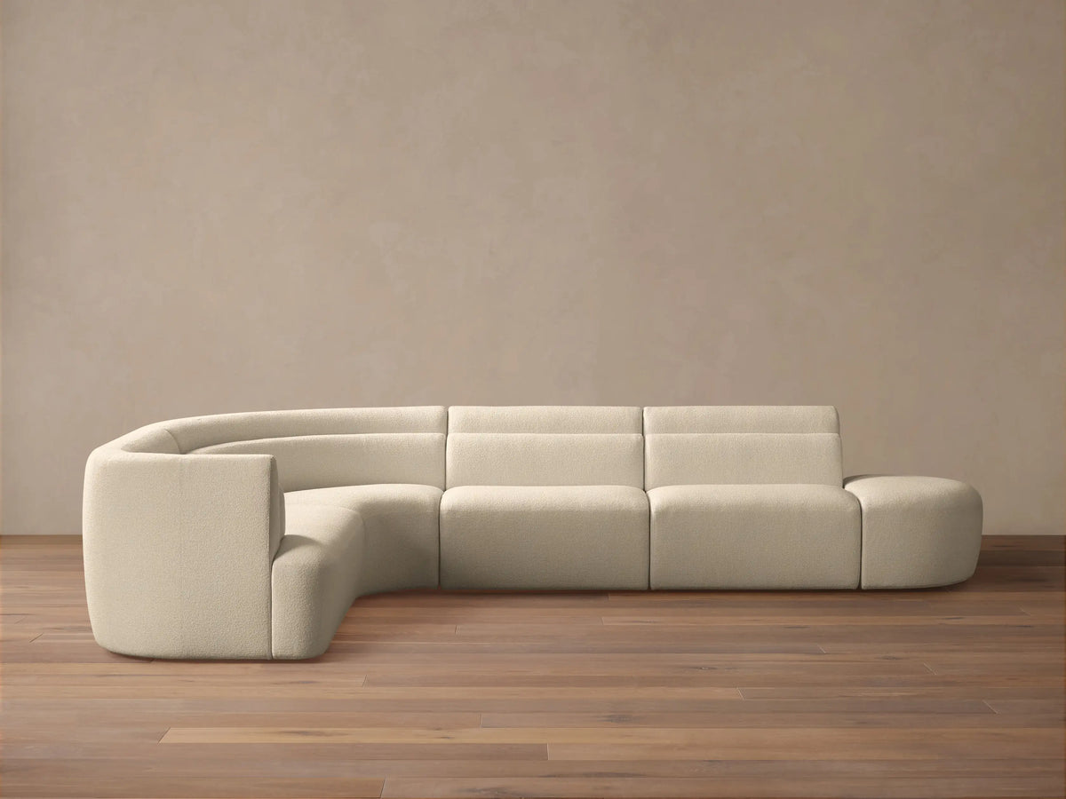 Lovina Five-Piece Sectional: cream textured L-shaped sofa with curved arm, straight sections, & ottoman on wood floor.