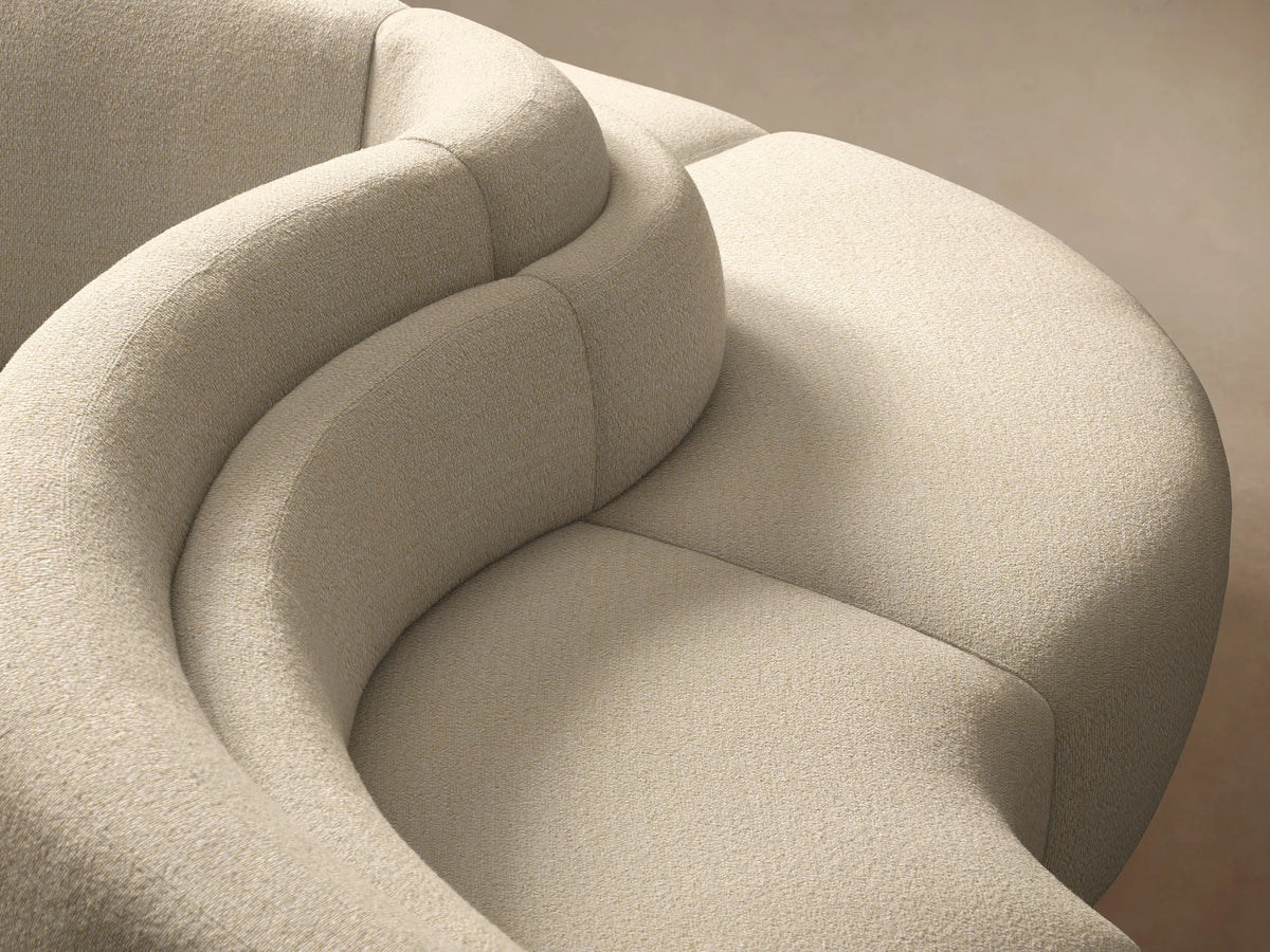Cream Lovina Five-Piece Sectional, gracefully curved, modular and low-profile, on a wooden floor against a neutral wall.