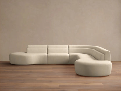 Cream bouclé Lovina Five-Piece Corner Sectional, L-shaped with curved right end, on wood floor against a neutral wall.