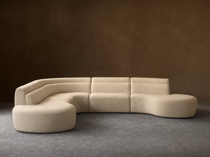 Cream bouclé Lovina Five-Piece Corner Sectional, L-shaped with curved right end, on wood floor against a neutral wall.