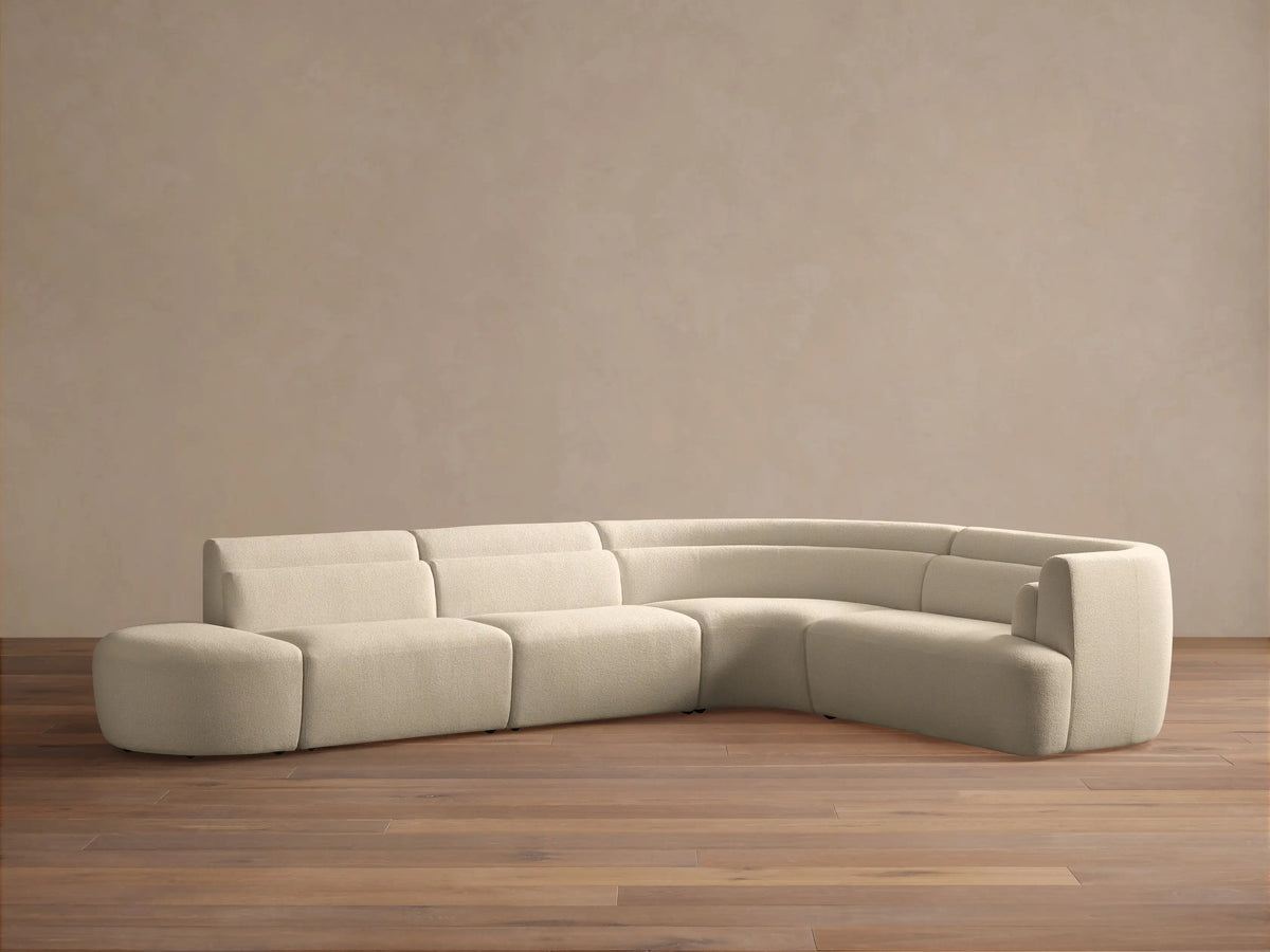 Cream Lovina Five-Piece Sectional: ottoman, 2 armless chairs, corner wedge, right arm chair, forming an L-shape.