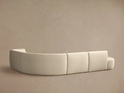 Close-up of a light beige, curved Lovina sectional sofa with textured fabric, showing soft seat cushions and backrests.
