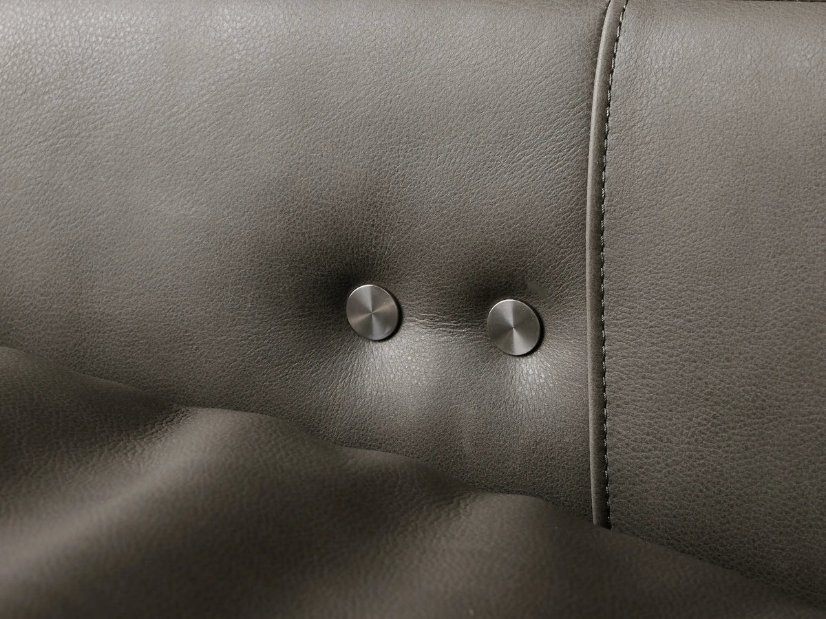 Close-up, angled view of a grey leather Rowland Tailored High-Back Motion Recliner's reclined backrest & arm.
