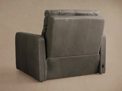 Dark gray Rowland Tailored Motion Recliner, side view, fully reclined with footrest extended against a beige wall.