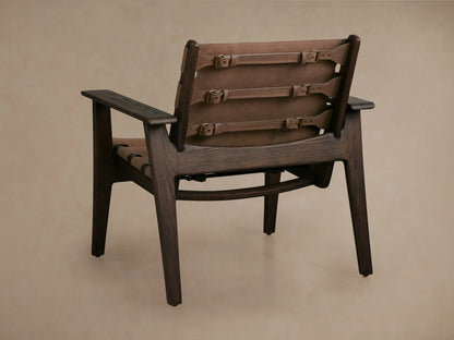 Reggie Nubuck Leather Chair backrest with brown leather sling-style, secured by antique brass buckles, oak wood frame visible.