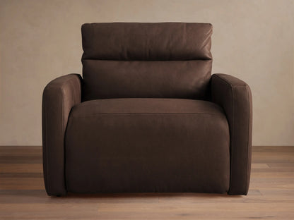 Rowland Tailored dark brown leather high-back motion recliner. Angled view, tailored design, plump cushions, on wood floor.