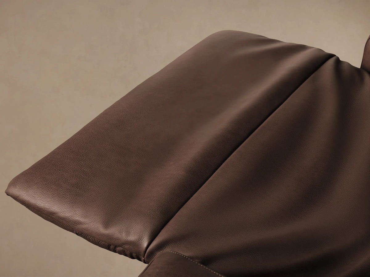 Frontal view of a tailored, high-back Rowland motion recliner in rich brown leather, centered on a wood floor.