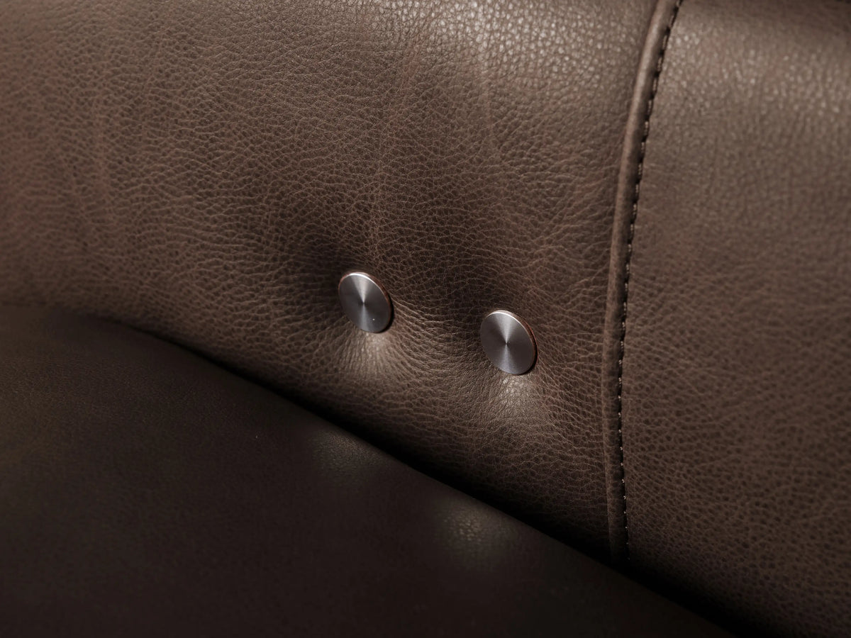 Rowland Leather Recliner: close-up of a soft, rich brown leather cushion with subtle texture, angled against a light background.