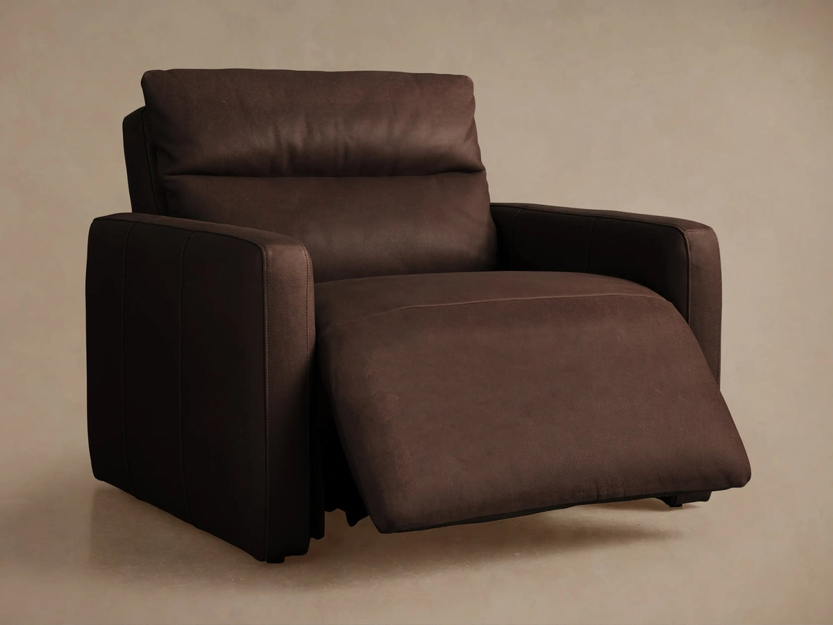 Close-up of Rowland Tailored Leather Recliner with textured brown leather upholstery, two round silver buttons, and stitching.