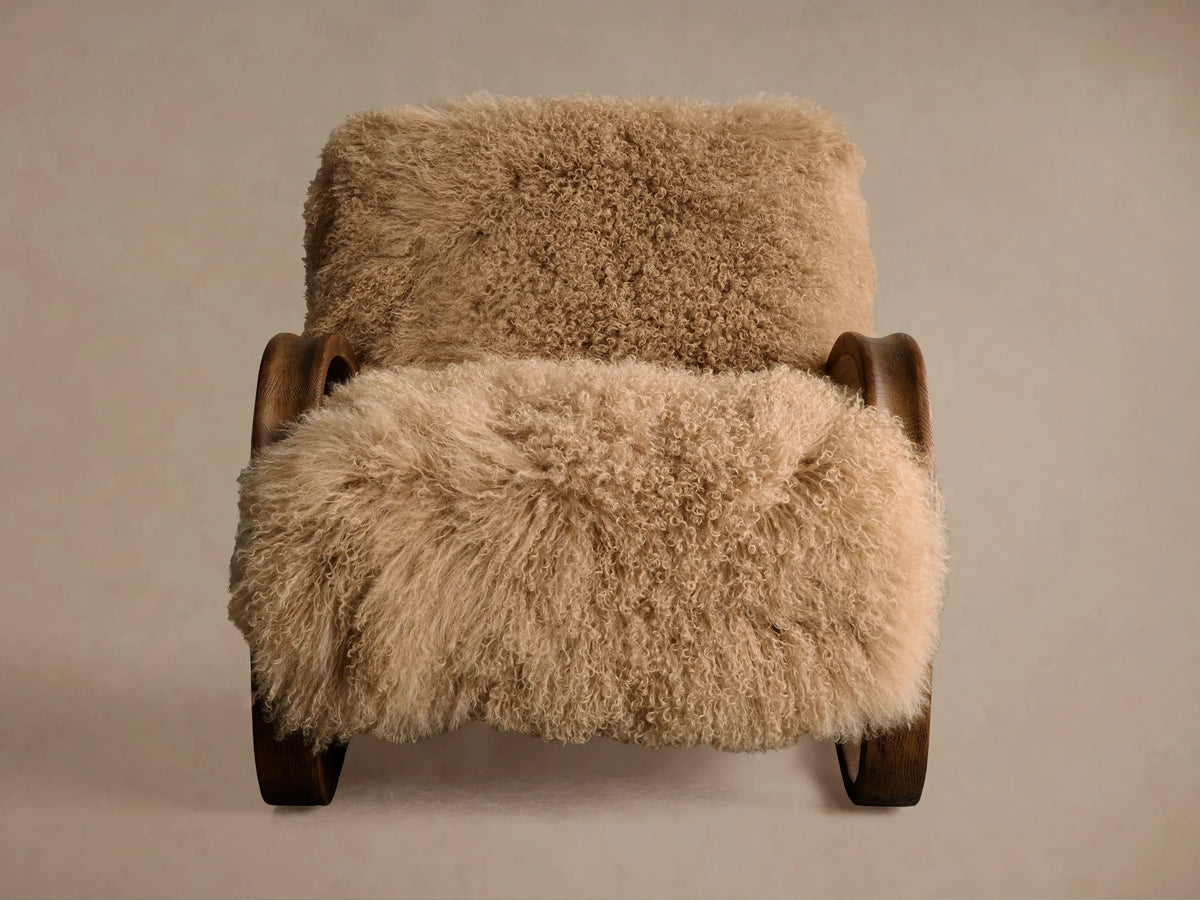 Front view of the cream Allora Mongolian Shearling Chair with soft, shaggy shearling upholstery and curved mocha wood frame.