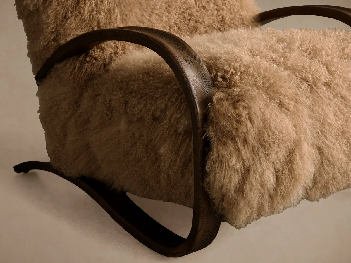 Front view Allora Mongolian Shearling Chair with fluffy, light brown curly shearling & curved dark Mocha red oak wood arms.