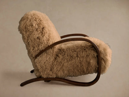 Allora Mongolian Shearling Chair close-up. Plush cream shearling texture with a curved dark mocha wood armrest.