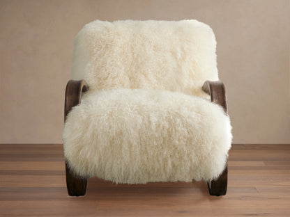 Side view of the fluffy Mongolian Ivory Allora Chair with an exposed dark wooden frame, positioned in a modern living room.