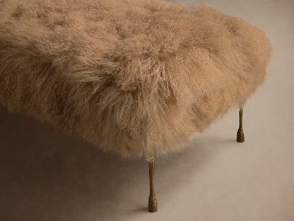 Front view of the beige Gwen Mongolian Shearling Bench, featuring shaggy fur and thin brass legs.