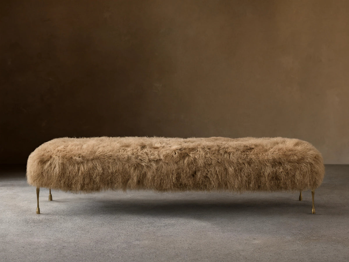 Front view of the Tan Gwen Mongolian Shearling Bench, covered in textured shearling, with four slender hand-painted brass finish legs.