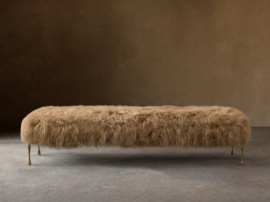 Front view of the Tan Gwen Mongolian Shearling Bench, covered in textured shearling, with four slender hand-painted brass finish legs.