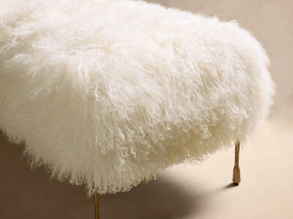Angled view of the white Gwen Mongolian Shearling Bench, with long curly shearling and hand-painted brass iron legs.