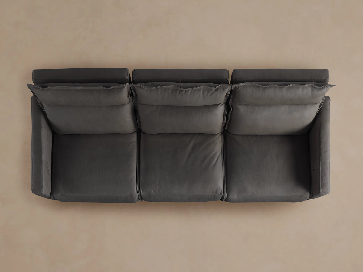 Rowland Leather Three-Piece Motion Modular Sofa in dark brown, with left and right recliners extended on a beige background.