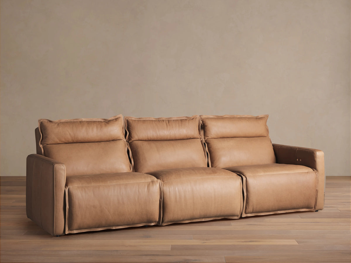 Rowland Leather Three-Piece Motion Modular Sofa in tan leather, featuring left, armless, and right recliners on a wooden floor.