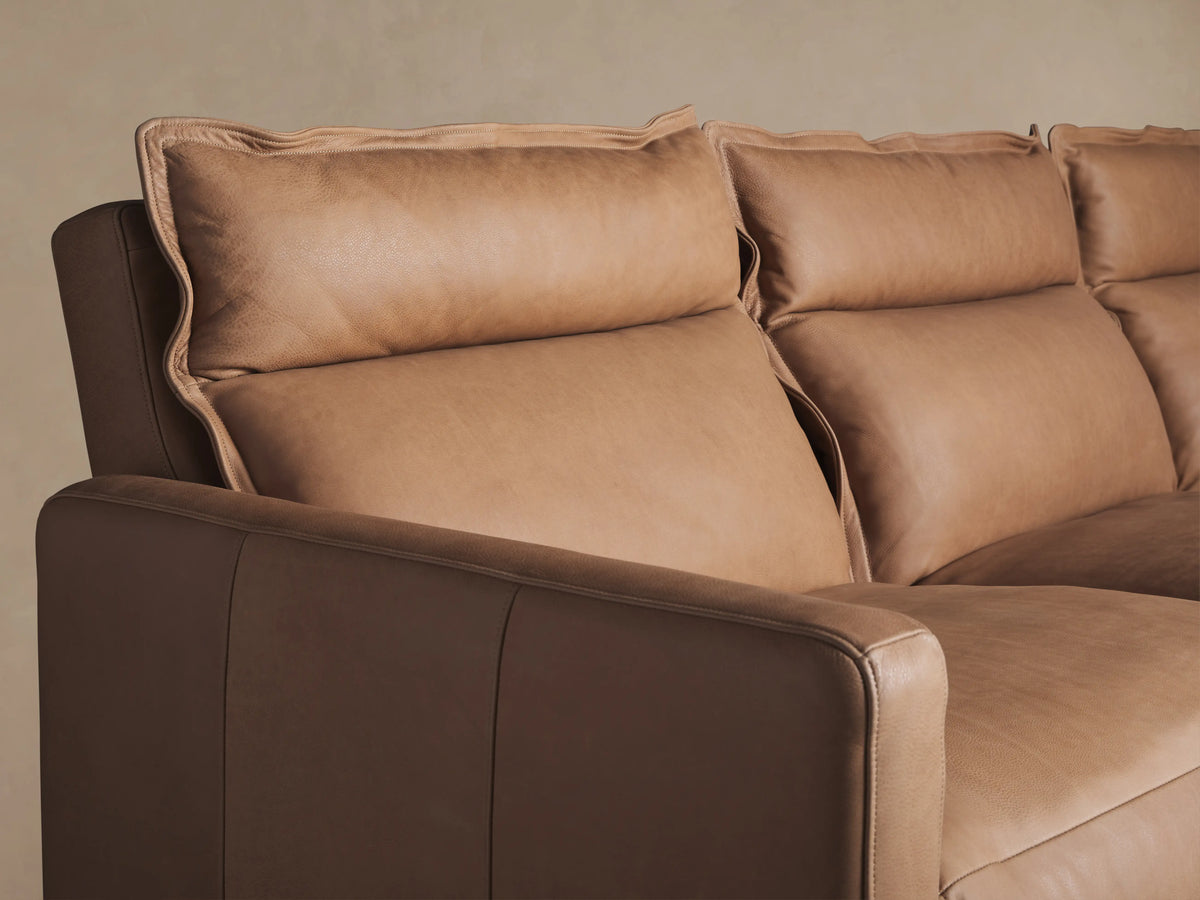 Rowland Leather Three-Piece Motion Modular Sofa in tan leather. Features three recliners with visible seams, wooden floor, neutral wall.