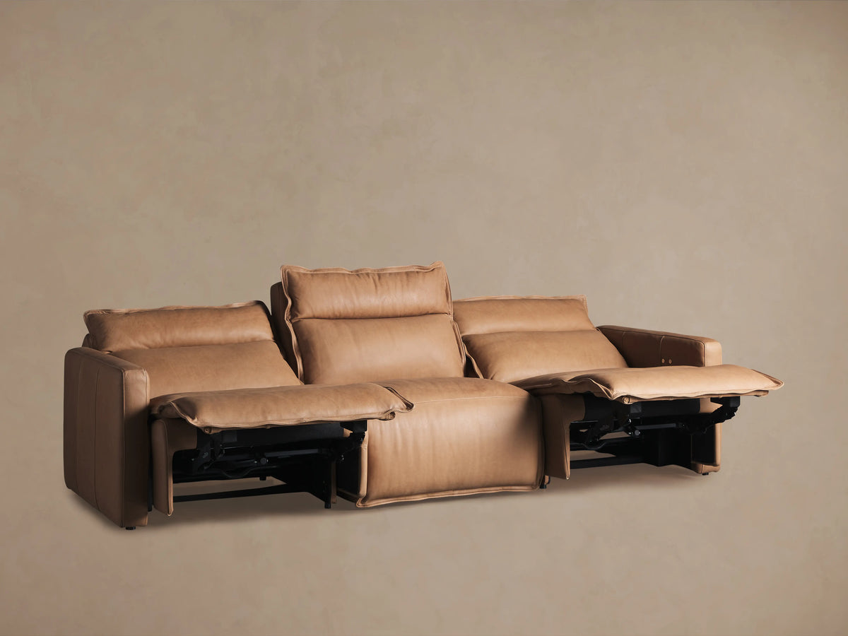 Back view of Rowland Leather Three-Piece Motion Modular Sofa with tan leather upholstery. Shows three recliner sections with visible seams.