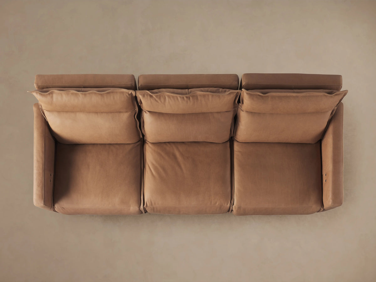 Rowland Leather Three-Piece Motion Modular Sofa in tan, fully reclined with visible footrests. Composed of three sections, left and right with armrests.