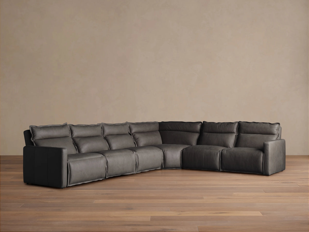 Rowland Leather Six-Piece Motion Sectional in a corner setup on wooden floor, dark leather upholstery, soft cushions, and plush backrests.