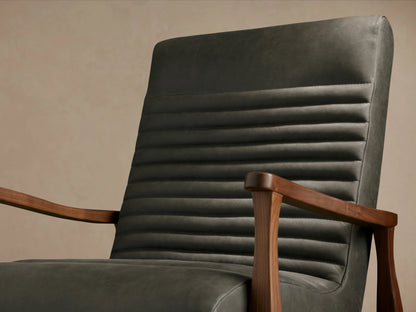 Nathaniel Leather Chair in dark leather with ribbed backrest, wooden arms and legs, on a wooden floor, front view.