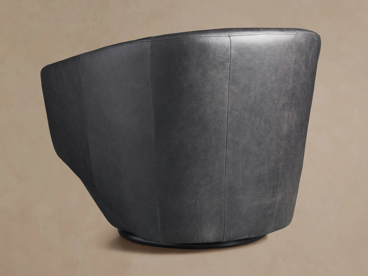 Pelton Leather Swivel Chair, front view. Dark gray distressed leather, rounded bucket design with a black swivel base.