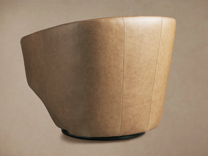 Pelton Leather Swivel Chair, angled rear view. Light tan leather, vertical stitching, dark round swivel base.