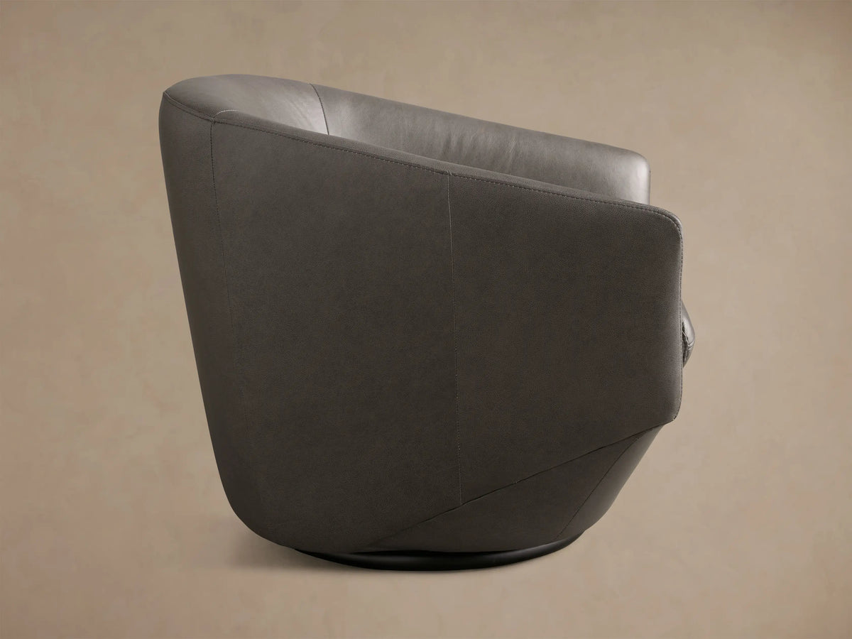 Front view of the dark gray Pelton Leather Swivel Chair, featuring a rounded barrel back, tapered base, and separate seat cushion.