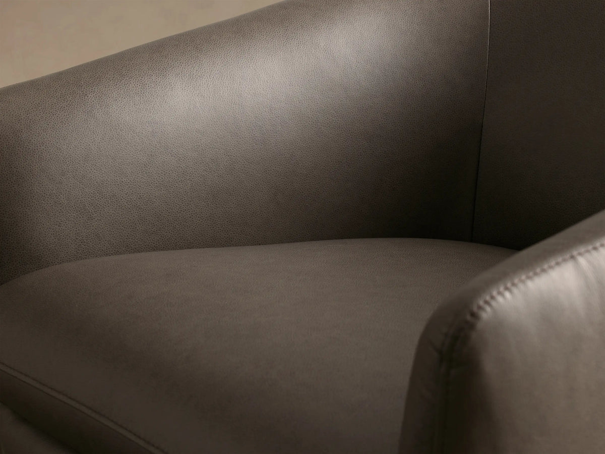 Rear view of the dark gray Pelton Leather Swivel Chair, featuring its smooth, tapered back with vertical stitching.