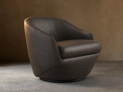 Front-side view of the dark gray Pelton Leather Swivel Chair, showing its rounded shape, deep seat, and dark swivel base.