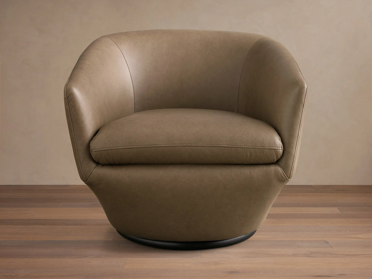 Front and side view of a Taupe Pelton Leather Swivel Chair with a rounded back, plump seat cushion, and a black circular swivel base.