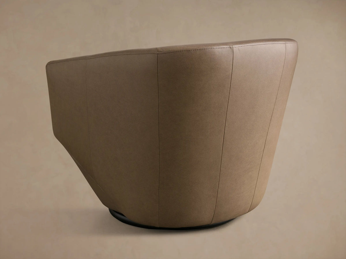 Close-up of the taupe leather on the Pelton Leather Swivel Chair, showing smooth texture and fine stitching along the curved arm and back.