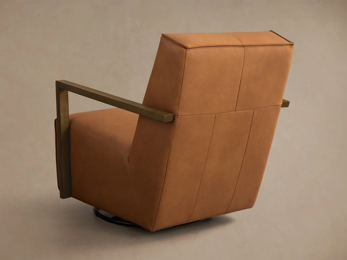 Close-up of the Cognac Walsh Leather Swivel Glider, showing the leather seat, backrest, and dark wood armrests.
