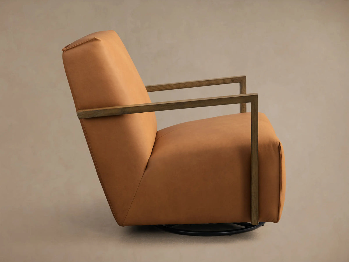 Rear three-quarter view of a tan leather Walsh Leather Swivel Glider with wooden armrests and vertical seam details on the back.