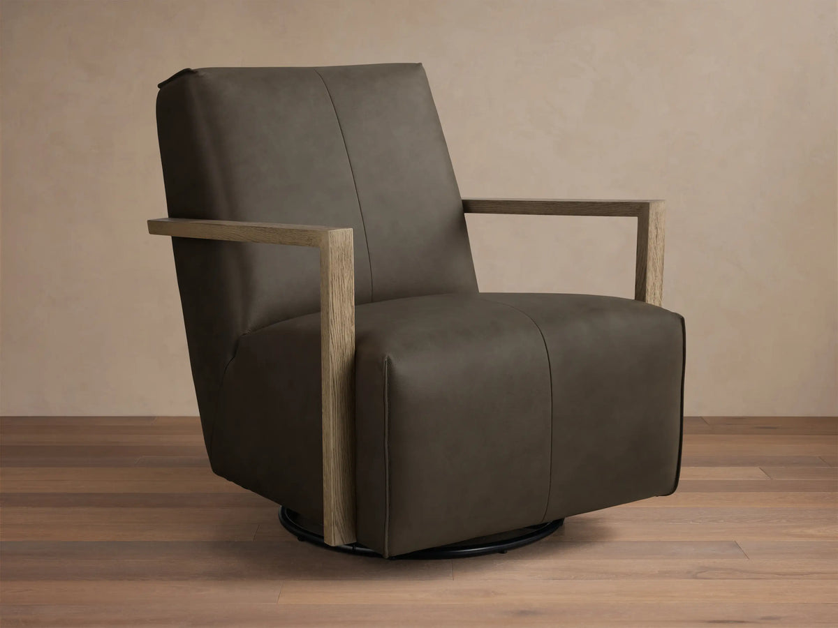 Angled front view of a dark taupe Walsh Leather Swivel Glider with light wooden armrests and a black swivel base.