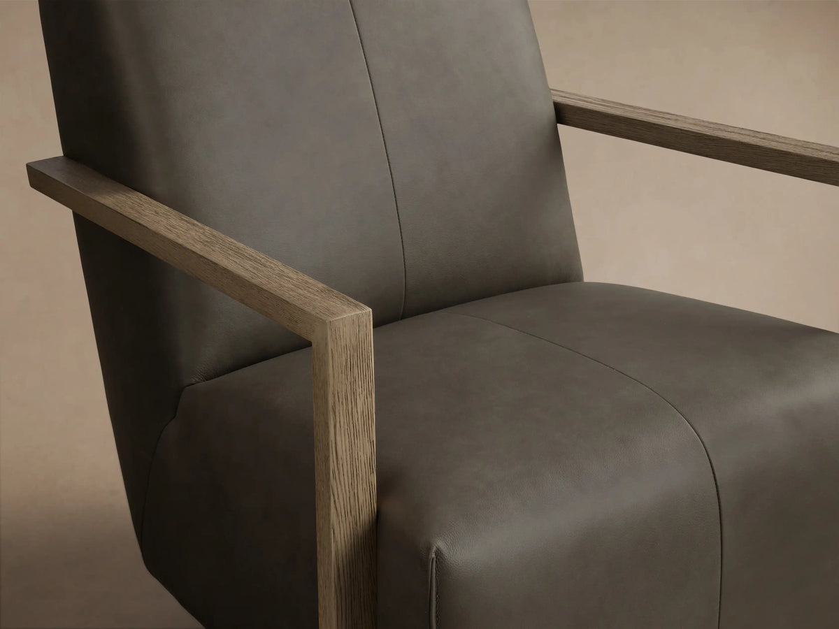 Front view of the Taupe Walsh Leather Swivel Glider with light wood arms and a black swivel base.