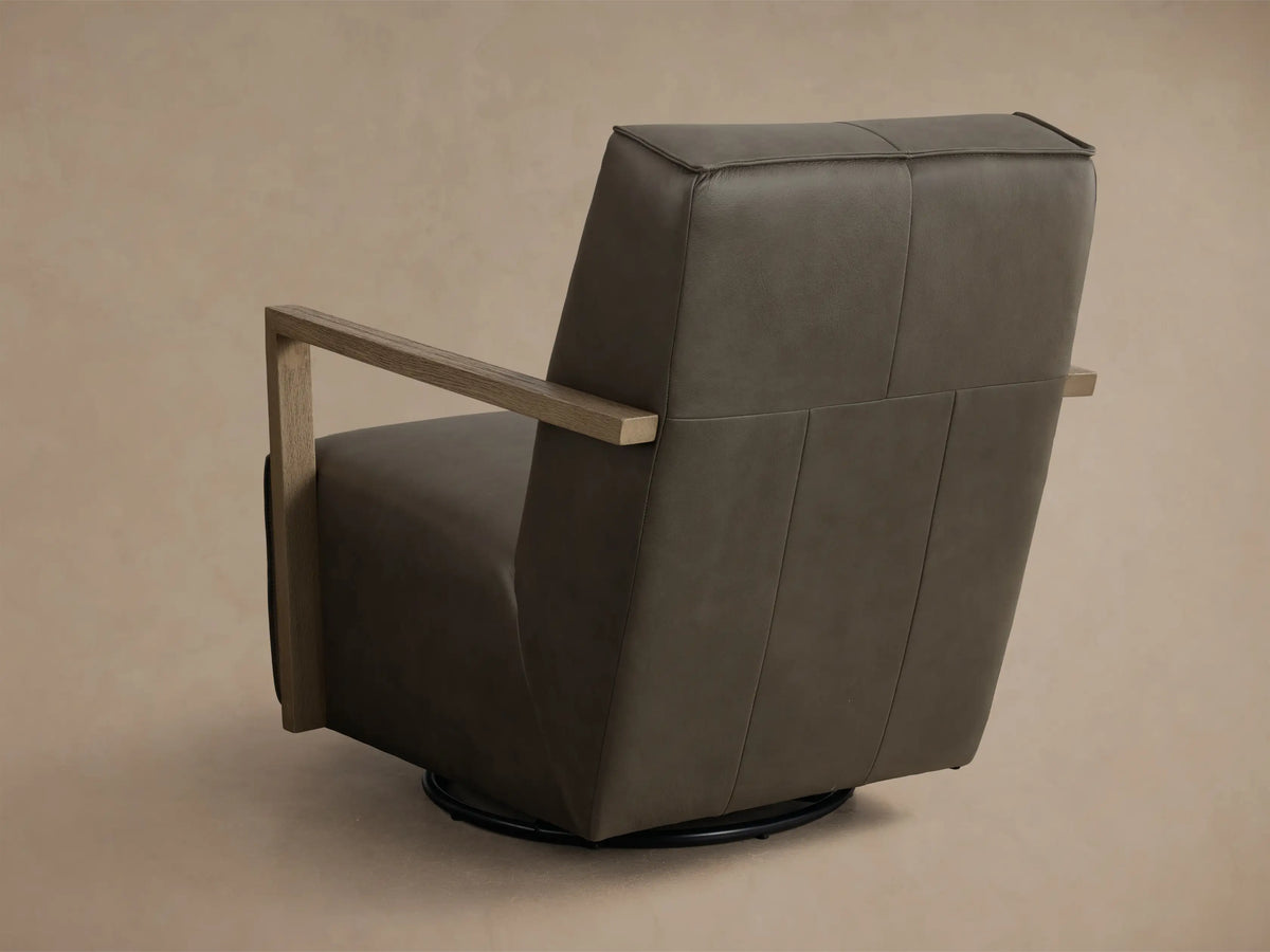 Close-up view of the dark gray leather Walsh Leather Swivel Glider with light brown wooden armrests, highlighting the smooth texture.