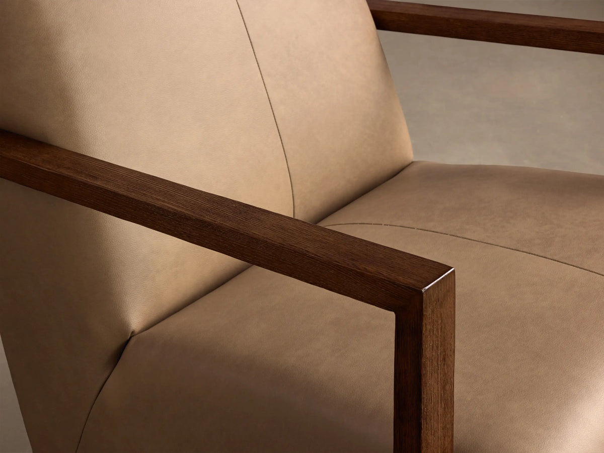 Front view of the tan Walsh Leather Swivel Glider with dark wood arms and a deep cushioned square back.