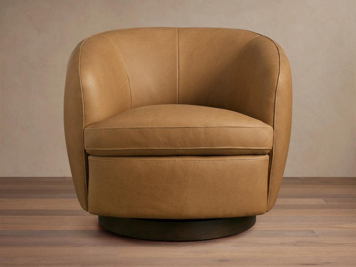 Tan Cerrito Leather Swivel Chair with rounded, cushioned backrest and seat. Features a solid black swivel base and smooth leather finish.