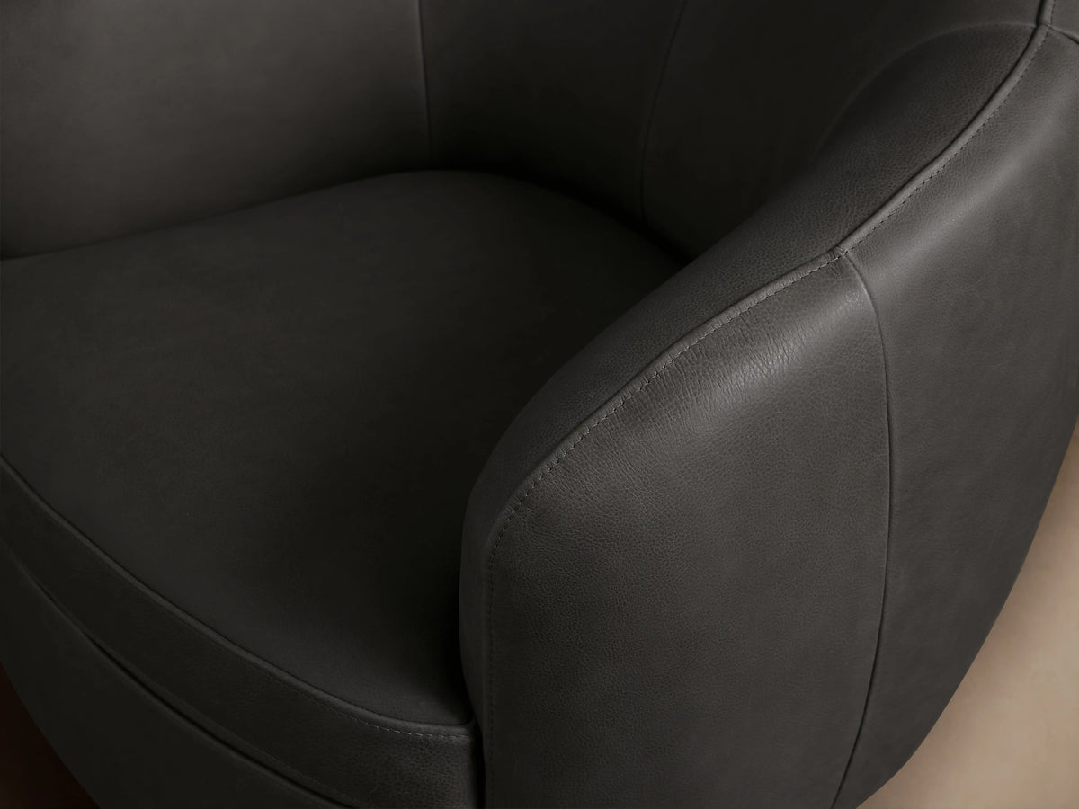 Cerrito Leather Swivel Chair in dark gray leather, featuring a rounded backrest and seat on a circular swivel base, with subtle stitching.